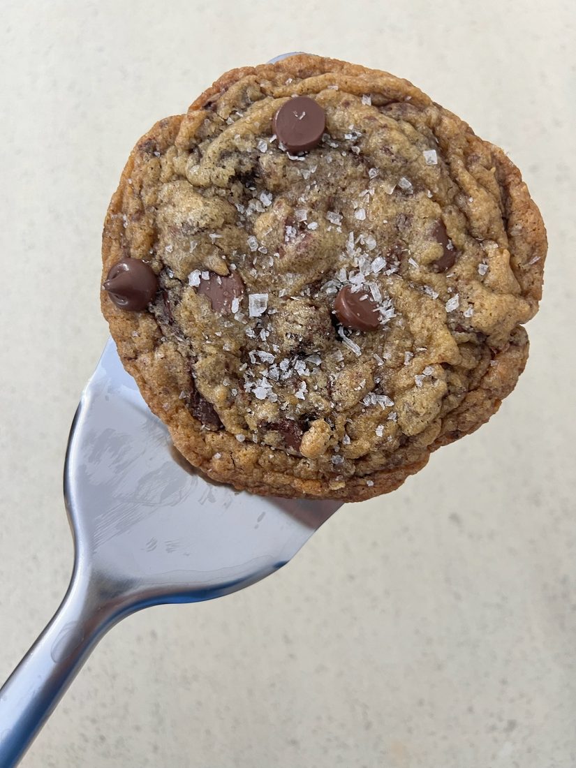 A sourdough chocolate chip cookie topped with flaky salt