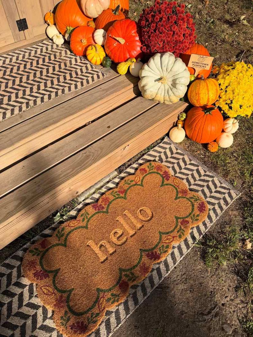 Doorstep with pumpkins, mums and a hello mat